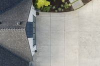 the roof of a house with stone and brick walls and a concrete door and side walk