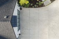 the roof of a house with stone and brick walls and a concrete door and side walk