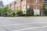 two people walking and a man riding a bike on the sidewalk near the intersection of the street