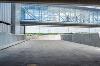 an overpass above a building with a glass bridge that goes over it to the left