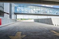 an overpass above a building with a glass bridge that goes over it to the left