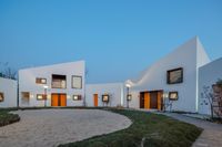 two houses are set side by side with grass in front of them at night on a clear day