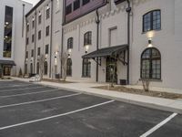 the outside view of some commercial buildings and parking lot space near buildings with white brickwork