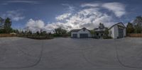 the front yard has a driveway and a garage in it, where you can see a home from a fisheye lens