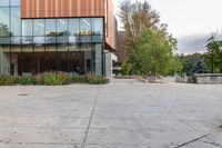 an empty courtyard of a school building with the entrance open to the campus in front of the building