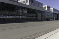 a fire hydrant is near an empty street outside an industrial building in the middle of an urban setting