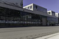 a fire hydrant is near an empty street outside an industrial building in the middle of an urban setting