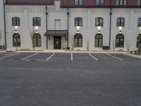 an empty parking lot with buildings on the side of it and some windows to the side