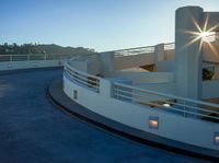 the building has a large railing outside of it in the evening, with the sun shining through