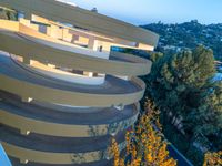 there is a circular spiral walkway on this building looking down onto the street below it