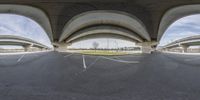 there is an upside down shot of a parking lot underneath a large overpass bridge