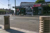 a city street is lined with cement columns for side - by - side parking space