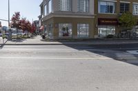 a yellow stop sign sitting next to a street curb on a city street intersection at a crosswalk