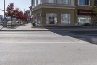 a yellow stop sign sitting next to a street curb on a city street intersection at a crosswalk