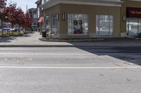 a yellow stop sign sitting next to a street curb on a city street intersection at a crosswalk