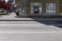 a yellow stop sign sitting next to a street curb on a city street intersection at a crosswalk