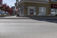 a yellow stop sign sitting next to a street curb on a city street intersection at a crosswalk