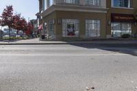 a yellow stop sign sitting next to a street curb on a city street intersection at a crosswalk