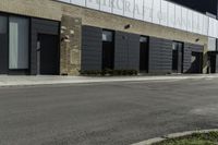 a motorcycle rider travels past a large building in a parking lot, with the city in the background