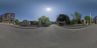 the view of the sun on a clear day from the street corner, looking into a two - way street