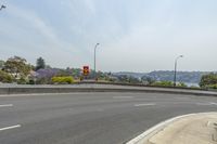 this is an image of a street corner near water and buildingss with trees in the background