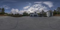 the front yard has a driveway and a garage in it, where you can see a home from a fisheye lens