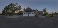 the view from behind of a driveway area at dusk, shows the garages and the driveway