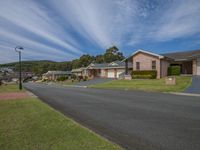 houses in residential neighborhood with green grass and trees on front and side of house with blue sky