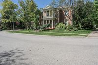 residential street with houses on one corner and trees to the other side of a road