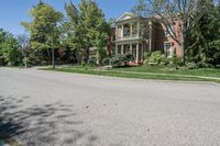 residential street with houses on one corner and trees to the other side of a road