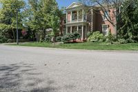 residential street with houses on one corner and trees to the other side of a road