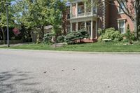 residential street with houses on one corner and trees to the other side of a road