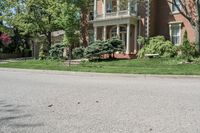 residential street with houses on one corner and trees to the other side of a road