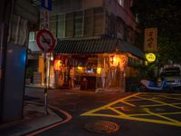 a small restaurant on a quiet street at night with no lights in it and signs warning drivers