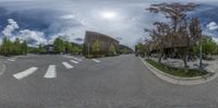 a mirror view of a street through a fish eye lens with a bench in front of it