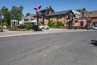 a road is surrounded by a very big house with a canadian flag flying high above it