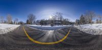 a 360 - angle view of a road with yellow lines and snow covering the ground