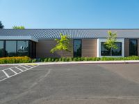 a building with a large parking lot and grass in front of it that is vacant