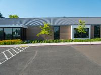 a building with a large parking lot and grass in front of it that is vacant