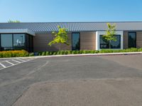 a building with a large parking lot and grass in front of it that is vacant