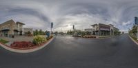 a fisheye shot of two shops by the street with sky in background that has clouds