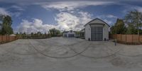 a 360 - camera shot of a skate park and garage with the sky in the background