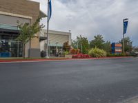 a street scene with empty parking space on either side of the road and flags on both sides