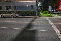 the yellow lines are in front of a gray building with cars parked on the side