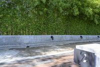 concrete boxes are placed in front of a green wall and a black metal planter