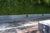 concrete boxes are placed in front of a green wall and a black metal planter