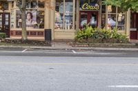 a city street filled with traffic at an intersection of two shops and a woman in a white dress