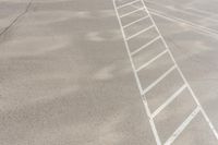 the man walks across the white lines of a parking lot for his vehicle to drive