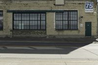 a building sits empty and vacant in front of a street sign with a large sign on it's side