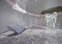 a large white stone bench inside of a lobby area next to a spiral staircase and large mirror walls